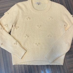cream colored sweater has little balls details